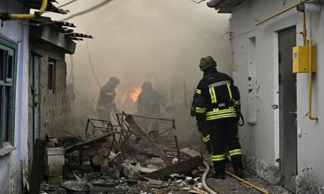 Ukrainian firefighters work to extinguish a fire in a house following Russian shelling in the city of Kherson, on 29 January