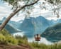 Woman on a swing overlooking spectacular fjord and mountains in Norway.