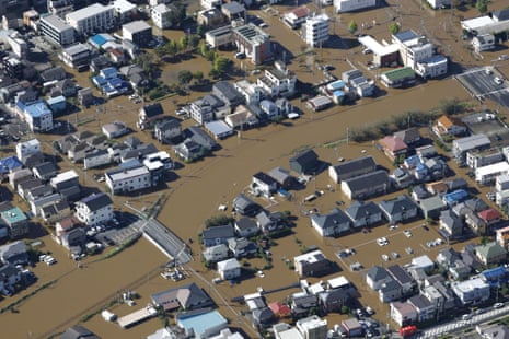 Aerial view of a Japan neighborhood submerged in brown floodwater from typhoon rains