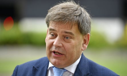 Andrew Bridgen in a suit and tie giving an interview outdoors