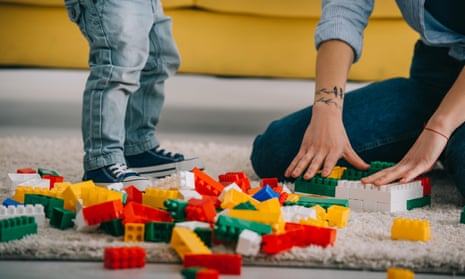 child and parent playing with lego