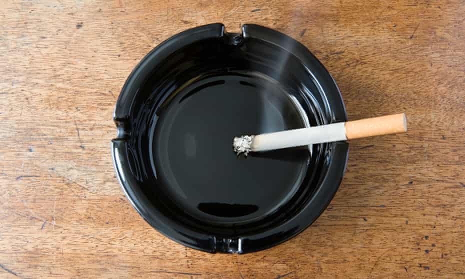Burning cigarette in a black ashtray