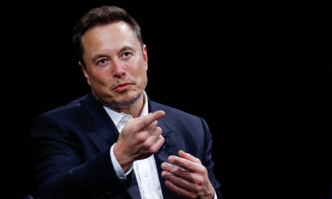 Elon Musk in suit points a finger