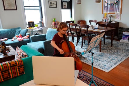 a child playing a cello inside her home