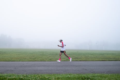 A runner jogs in front of heavy fog.