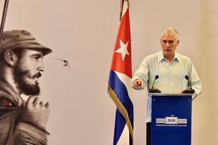 Miguel Díaz-Canel gives a speech next to a painting of Fidel Castro