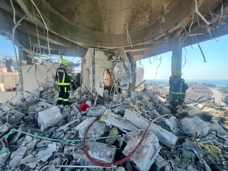 Workers in the rubble of a damaged building
