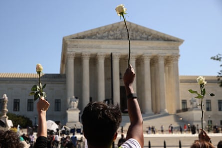 Members of Casa, an advocacy organization for Latino and immigrant people, hold up white roses in honor of Ruth Bader Ginsburg at the supreme court on Wednesday.