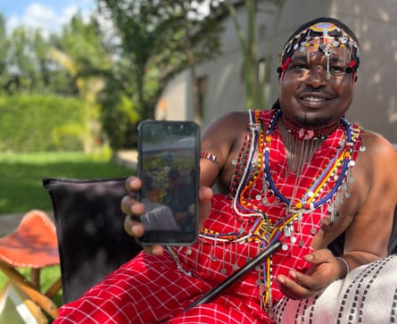 Ng’otiek Nelson holding up a phone to camera.