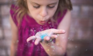 Girl blowing plastic glitter