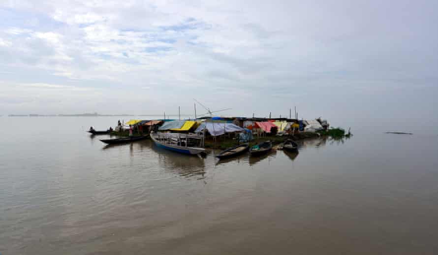 Villagers take shelter on an island they have made out of boats and rafts in the flood waters of Morigaon district of Assam state