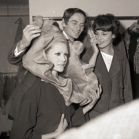 French couturier Pierre Cardin, and a model show an extravagant hat to his friend, actress Jeanne Moreau, right, in 1963.