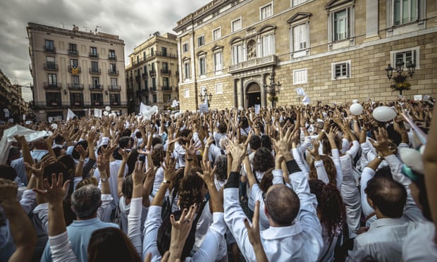 People raise their hands during a protest in favour of talks and dialogue in Sant Jaume square in Barcelona.