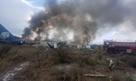 Firefighters douse flames at the site of the Aeromexico crash.