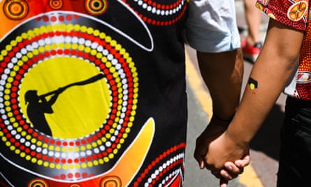 Protesters hold hands during the Treaty Before Voice Invasion Day protest in Melbourne.