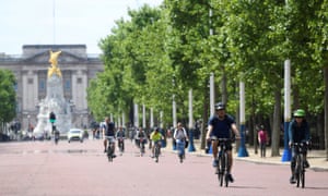 People are seen cycling along the Mall, London, on 17 May.