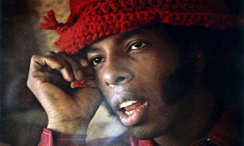 Sly Stone pictured closeup in a red woollen hat.