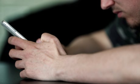 Um jovem usando seu smartphone para jogar