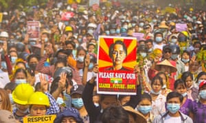A protester holds up a poster featuring detained civilian leader Aung San Suu Kyi during a demonstration against the military coup in February 2021.