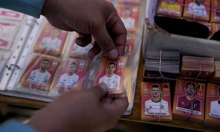 A close up of an album, showing Lionel Messi stickers.