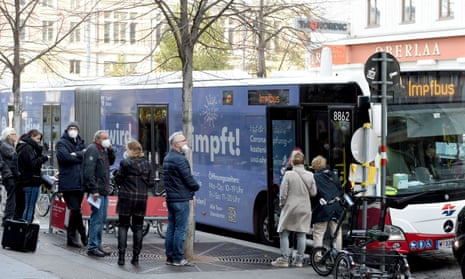 People queue to receive jabs from a Covid vaccination bus in Vienna, Austria