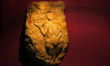 Sculpture d'une figure féminine accroupie tenant une corne de croissant dans sa main droite