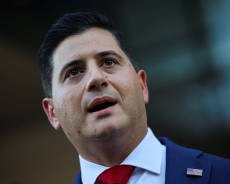 A man in a navy blue suit speaking