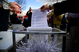 A protester feeds a Russian election ballot into a shredder
