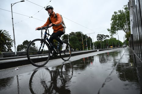 A person riding a bike through wet weather