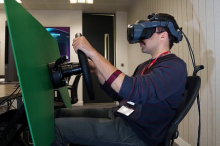 A man sits in a chair with a virtual reality headset on