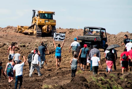 people stand in front of a construction vehicles at a construction site