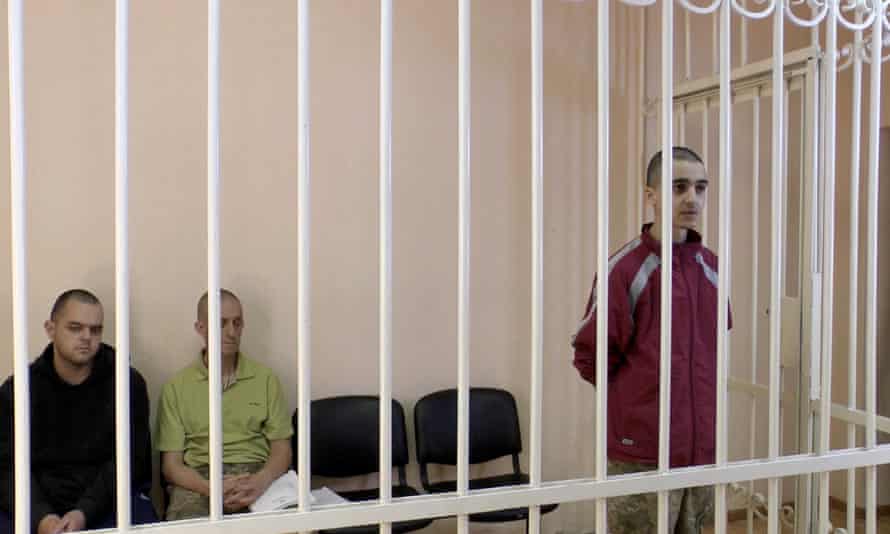 A still image, taken from footage released on June 8, 2022 from of the Supreme Court of the self-proclaimed Donetsk People’s Republic, showing Britons Aiden Aslin, Shaun Pinner and Moroccan Brahim Saadoun captured by Russian forces during a military conflict in Ukraine, in a courtroom cage.