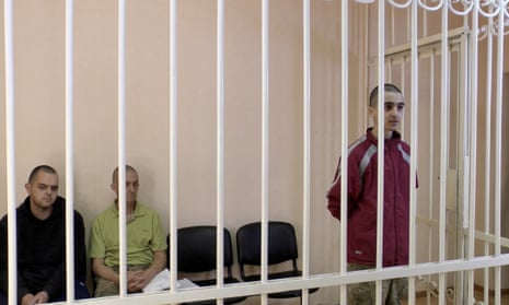 A still image, taken from footage of the Supreme Court of the self-proclaimed Donetsk People’s Republic, shows Britons Aiden Aslin, Shaun Pinner and Moroccan Brahim Saadoun captured by Russian forces during a military conflict in Ukraine, in a courtroom cage at a location given as Donetsk, Ukraine.