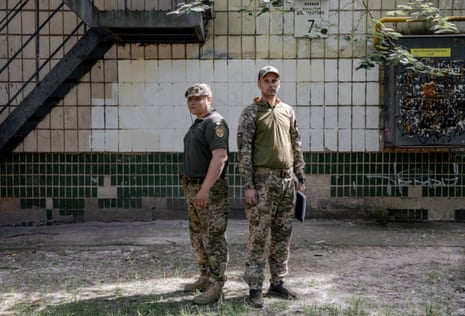 Pavlo Pimakhov and Yuriy Pikhota standing in front of a run-down building