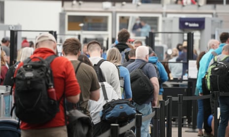 Travelers wait at a security checkpoint at Denver international airport in May. 