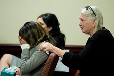 woman with face in hand as another woman behind her puts her hand on first woman’s shoulder