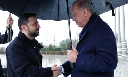 Erdoğan and Zelenskyy shaking hands under an umbrella