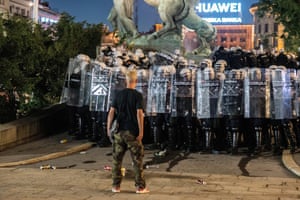 Police stand between protesters and parliament buildings in Belgrade on Friday night.