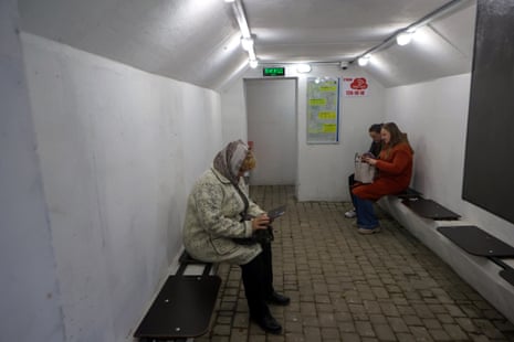 People sit inside one of the concrete bomb shelters in Kharkiv.