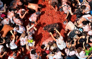 Revellers throw tomatoes amid a pile of red pulp