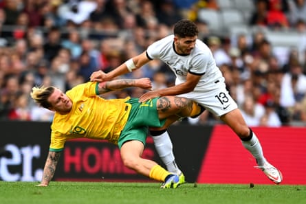 Australia’s Jason Cummings gets stuck in against New Zealand.