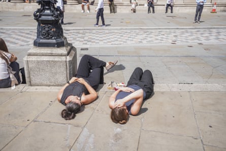 City workers relaxing in the sunshine during the lunch breach on a hot and humid day in London