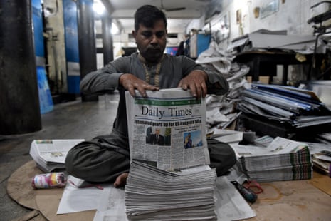 A worker bundles freshly printed copies of the Daily Times newspaper with a headline about the U.S. and Iran talks in Islamabad.