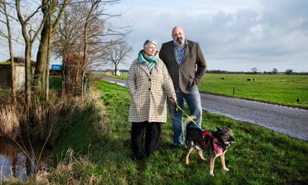 Joke Qureshi and her husband, Ray, standing by a country road with a dog