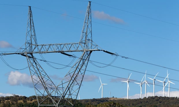High tension power lines standing near wind turbines