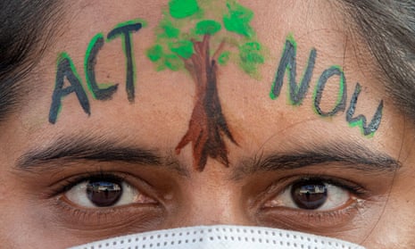 extreme close-up on woman's face with ACT NOW written on her forehead