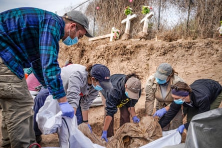 Texas State University graduate students lift the remains of a migrant from a gravesite at La Grulla cemetery on December 17, 2019 as part of the project Operation Identification.