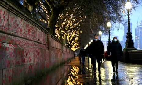People walk past the hand painted hearts at the Covid Memorial Wall in London, UK, on 26 December.