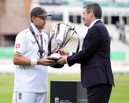 Joe Root is handed a trophy on the pitch at Edgabaston
