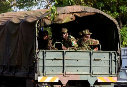 Soldiers in military fatigues seen sitting in the back of a transport